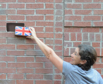 Dr. Kate Annett-Hitchcock, a member of The Quadrivium Project faculty rock back, places a brick into a hole in the wall.