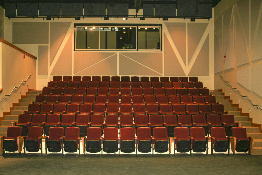 Interior photo of seating in the Kennedy-McIlwee Studio Theatre at NC State University. Seven rows of theatre seats inside a raked house. Fifteen seats each on rows B though G. Thirteen seats on row A (no steps), with eight that are removable for flexible accessible seating.