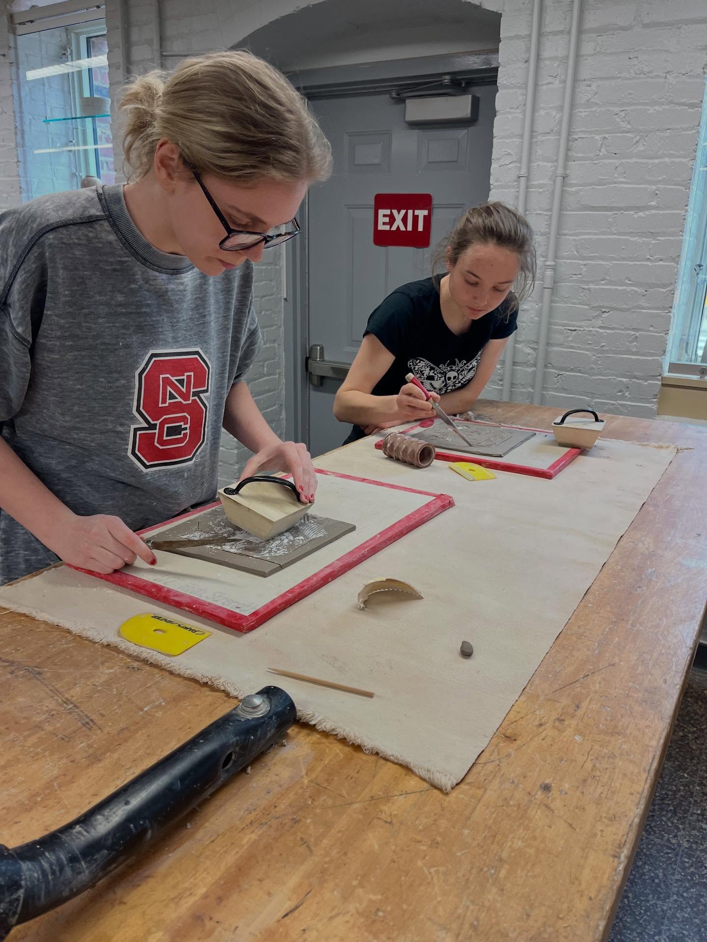 Two students carve their own rubber stamps at a Crafts Center class.